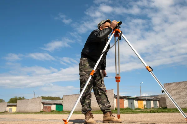 Theodolite on a tripod with construction worker — Stock Photo, Image