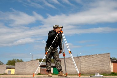 teodolit inşaat işçisi ile bir tripod üzerinde