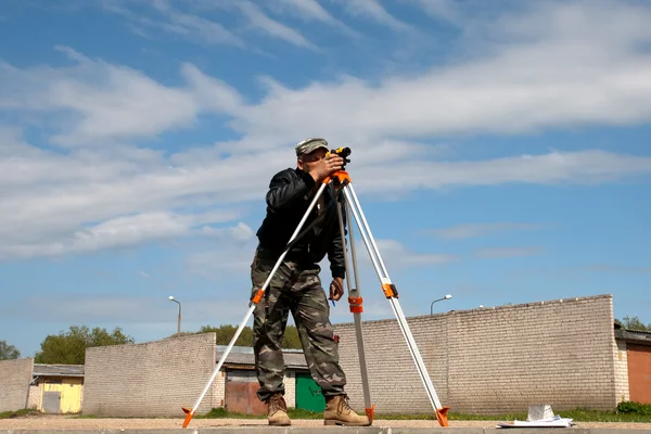 stock image Theodolite on a tripod with construction worker