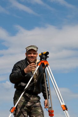 teodolit inşaat işçisi ile bir tripod üzerinde