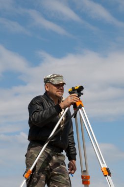 teodolit inşaat işçisi ile bir tripod üzerinde