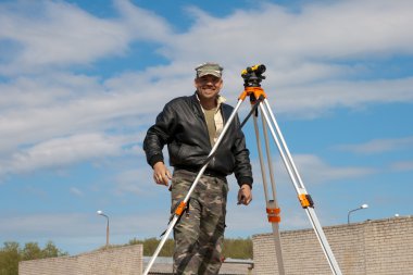 teodolit inşaat işçisi ile bir tripod üzerinde