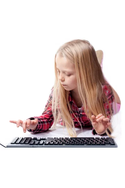 A little girl writes on the keyboard — Stock Photo, Image