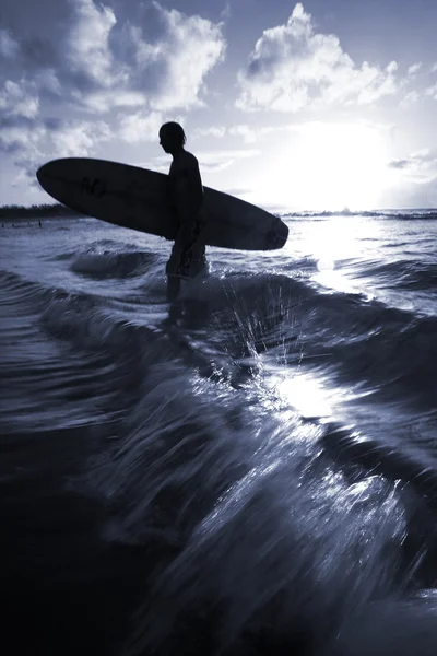 A surfer walks back in to the beach — Stock Photo, Image