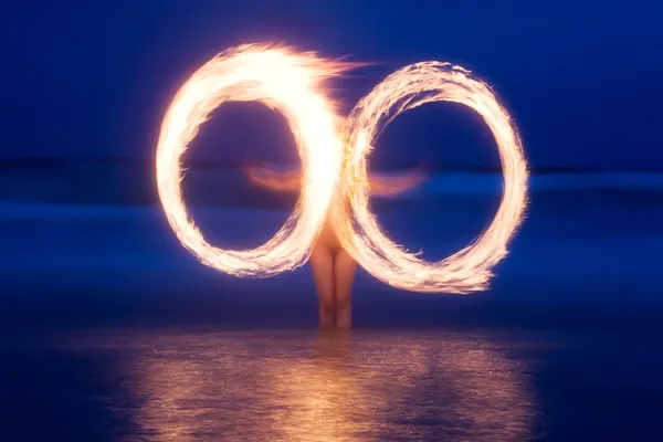Nacktmodell Feuer wirbelt am Strand — Stockfoto