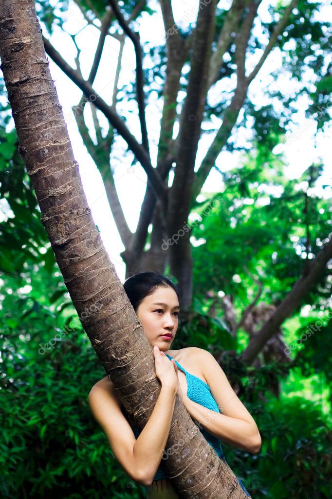 Asian girl hugging tree