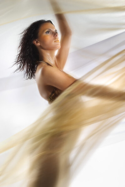 Model in studio surrounded by flowing cloth