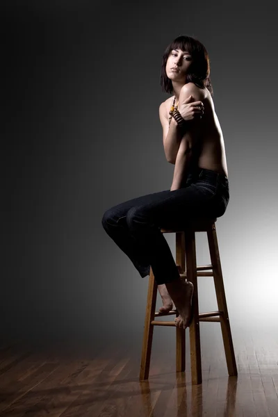 Alone girl sits on stool in studio — Stock Photo, Image