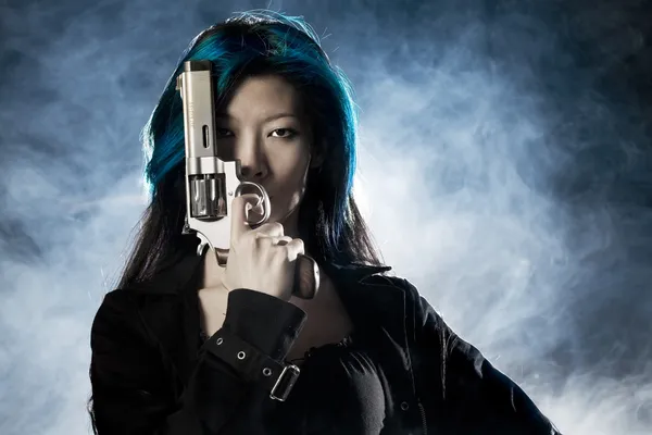Asiatische Schönheit hält Pistole mit Rauch — Stockfoto