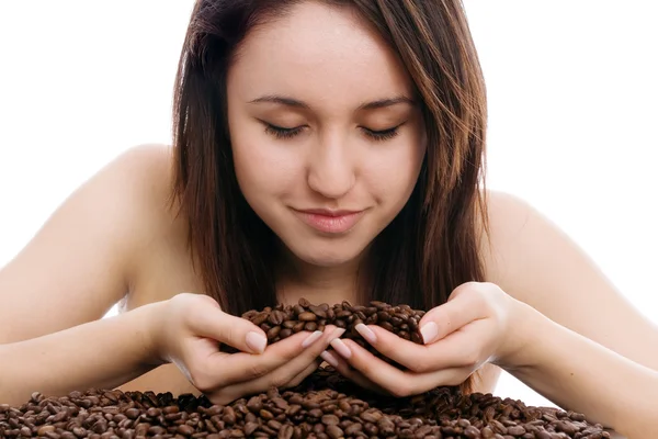 Beautiful young woman smelling coffee beans — Stock Photo, Image