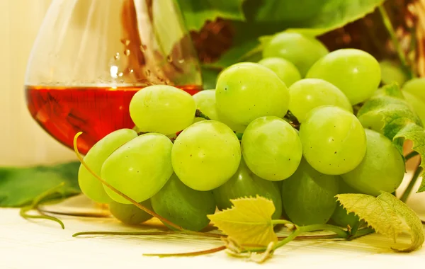 Massa vita druvor i en korg och ett glas vin — Stockfoto