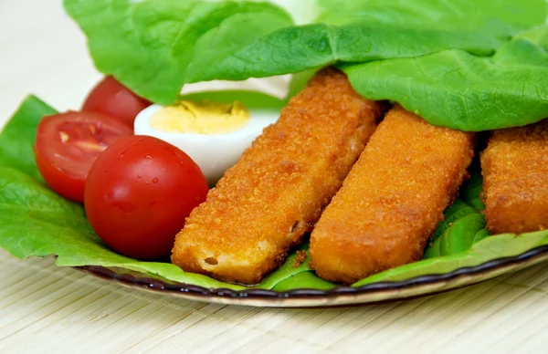 Balık kroket üzerine bir tabak yumurta salatası ile. — Stok fotoğraf