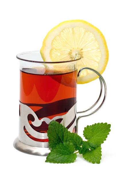 Tea in a glass holder and a sprig of lemon balm — Stock Photo, Image