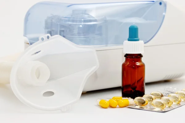 Nebulizador ultra-sônico e medicamentos em um fundo branco — Fotografia de Stock