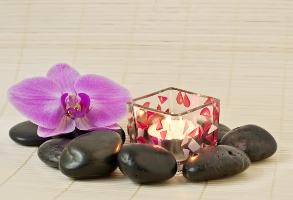 Rózsaszín orchidea és a zen kő, egy gyertyát — Stock Fotó