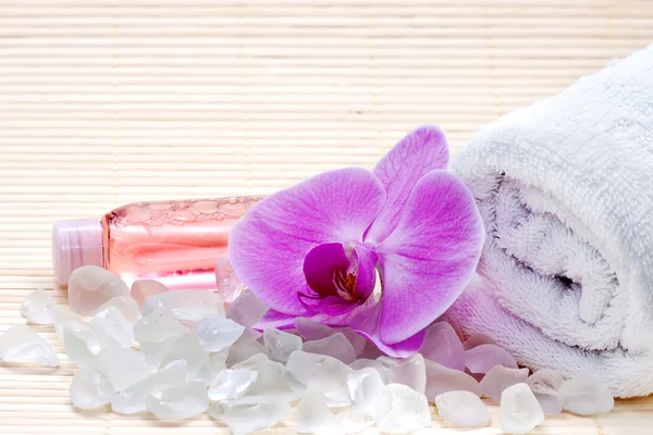 Pembe orkide, beyaz havlu ve banyo tuzları. Spa set — Stok fotoğraf