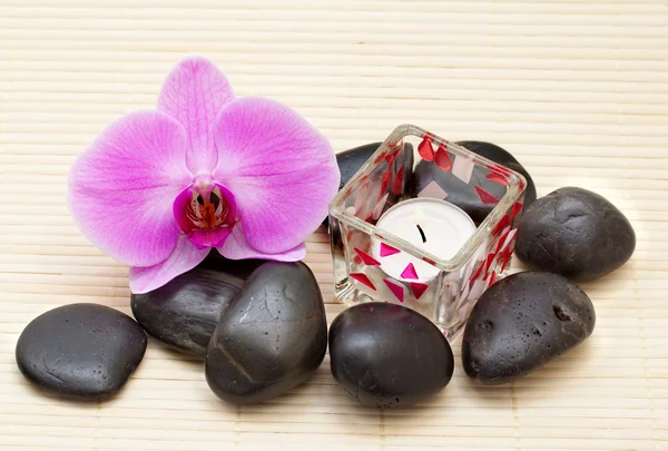Orquídea rosa e pedras zen com uma vela — Fotografia de Stock