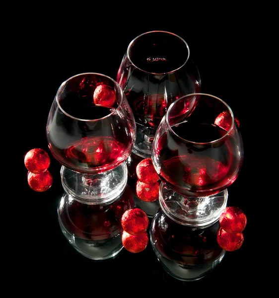 Gläser Wein und Schokolade auf schwarzem Hintergrund — Stockfoto