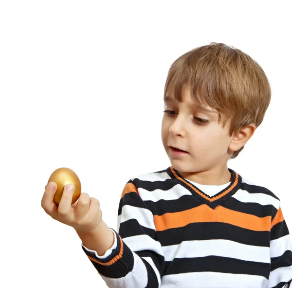 Мальчик держит золотое яйцо, изолированное на белом фоне — стоковое фото