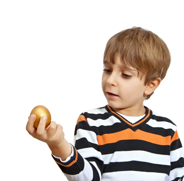 Jongen houden een gouden ei, geïsoleerd op witte achtergrond — Stockfoto