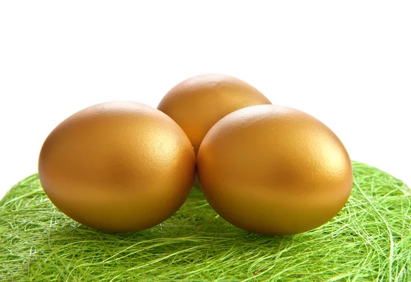 The golden egg on the grass. Isolate on white. — Stock Photo, Image