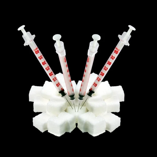 Jeringas de insulina pegadas al azúcar en bulto. aislado sobre un fondo negro — Foto de Stock