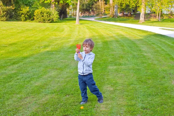 Ένα παιδί παίζει με μια μπάλα στο πάρκο — Φωτογραφία Αρχείου