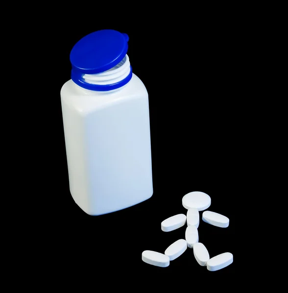 Um recipiente para comprimidos e um homem construído com comprimidos ao lado dele. . — Fotografia de Stock