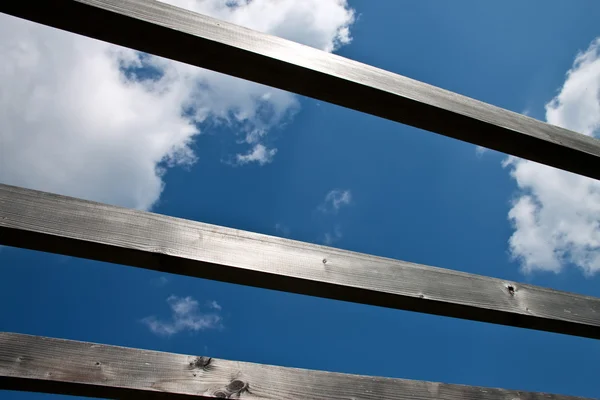 Błękitne niebo przez drewniane belki. — Zdjęcie stockowe
