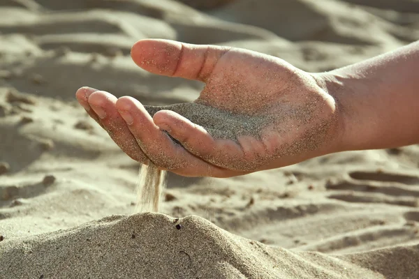 Areia fluindo através de seus dedos — Fotografia de Stock