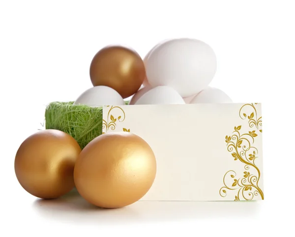 Goud en eenvoudige eieren met een uitnodigingskaart. — Stockfoto