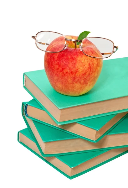 Pilha de livros com uma maçã e óculos em um fundo branco — Fotografia de Stock