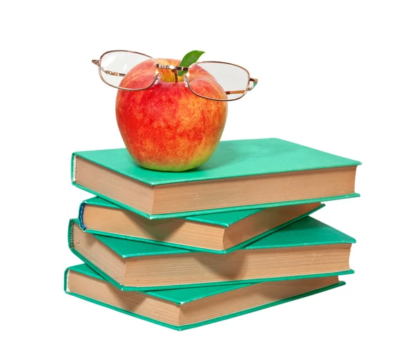 Pilha de livros com uma maçã e óculos em um fundo branco — Fotografia de Stock