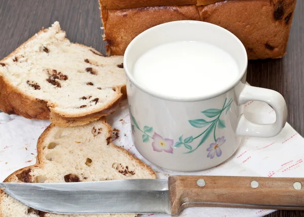 Молочная чашка и кусок торта на деревянном столе — стоковое фото