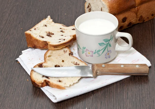 Kubek mleka i kawałek ciasta na stół drewniany — Zdjęcie stockowe