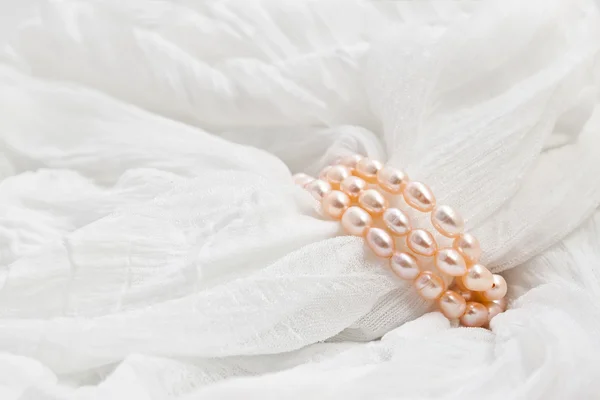 Rosa pärlor på en vit bakgrund. bröllop bakgrunder. — Stockfoto