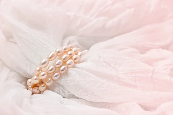 Rosa Perlen auf rosa Hintergrund. Hintergründe zur Hochzeit. — Stockfoto