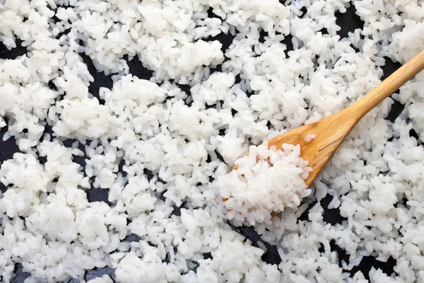 Pozadí vařené rýže s dřevěnou lžící — Stock fotografie