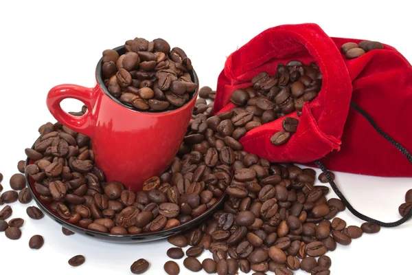 Kaffeekörner in einem Beutel und in einer roten Tasse — Stockfoto