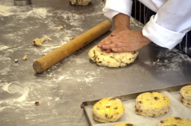 Baker working with dough on the counter clipart