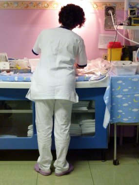 Nurse taking care of a newborn clipart