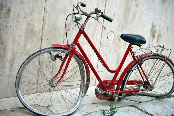 Сломанный велосипед у стены — стоковое фото