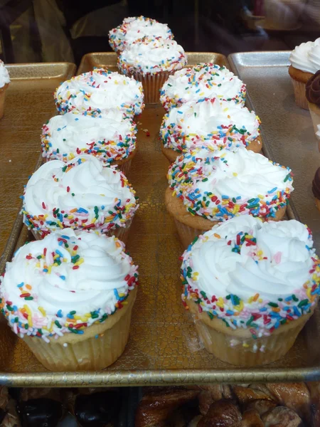 Färgglada cupcakes cream muffin arrangemang i ett konditori — Stockfoto