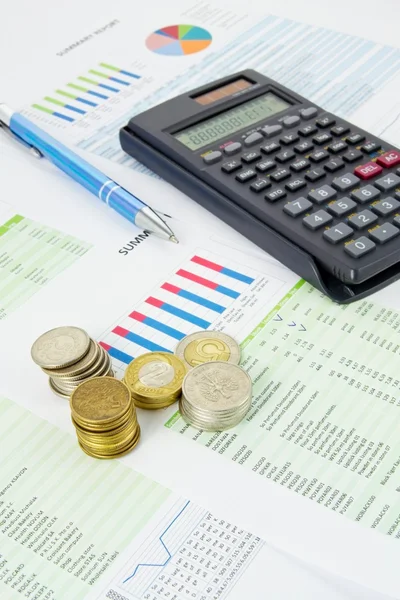 Calculadora, caneta, moedas em um fundo de negócios colorido — Fotografia de Stock