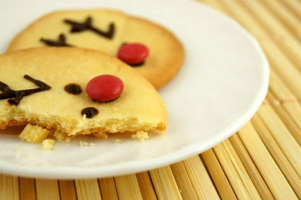 stock image Christmas reindeer bite cookie on white plate