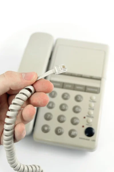 Mão segurando cabo de telefone liberado — Fotografia de Stock