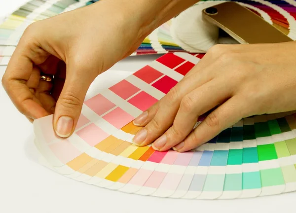 Frau wählt Farbe aus Buch mit Pantone-Mustern — Stockfoto