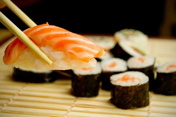 Des sushis japonais. Thon, bâtonnets sur serviette en bambou — Photo