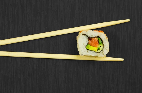 stock image Sushi and sticks isolated on black wooden board