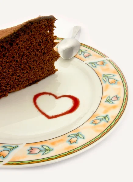 Coração, forma no prato com um pedaço de bolo — Fotografia de Stock